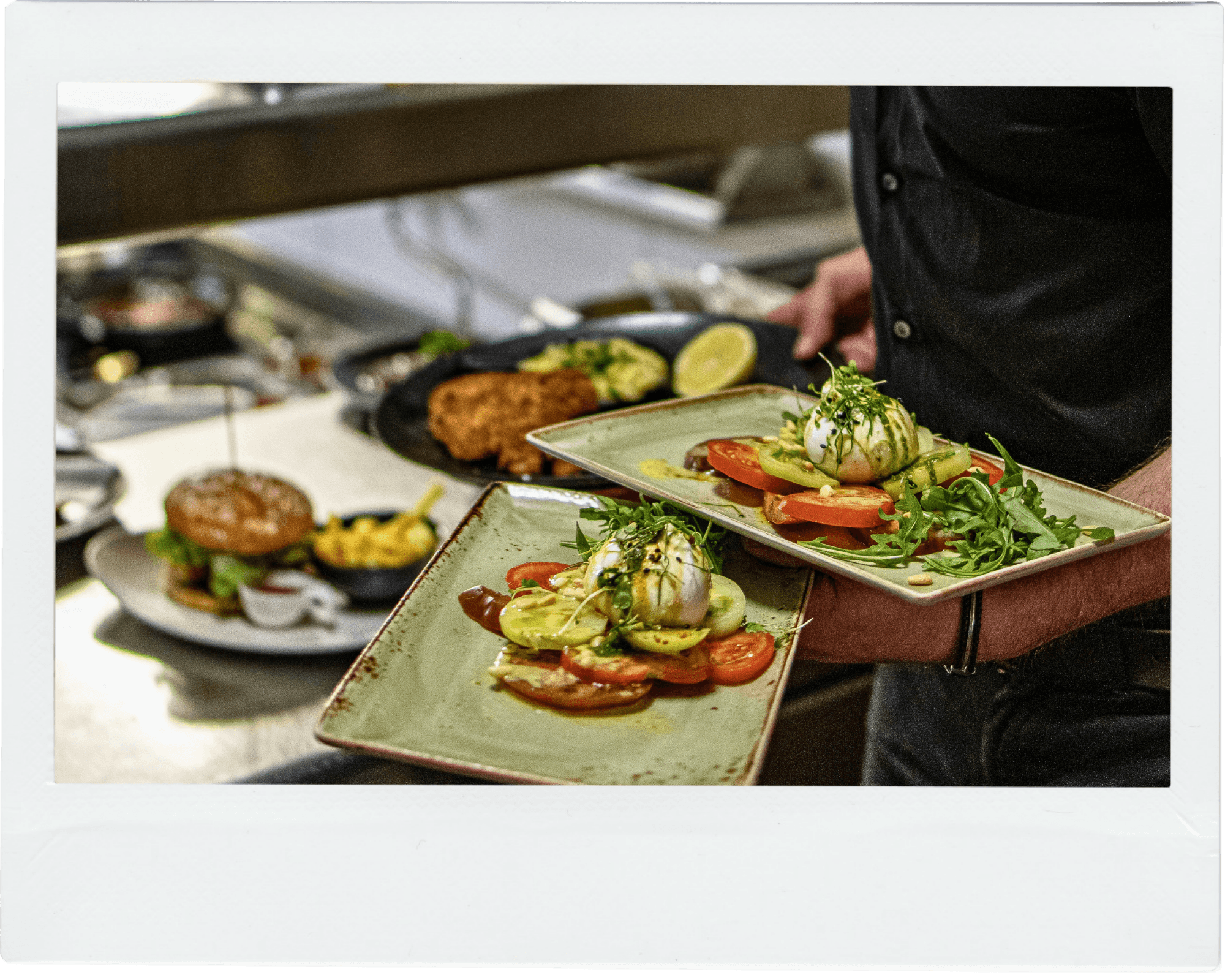 Chef presenting freshly prepared dishes in a commercial kitchen, representing hospitality waste collection services in Kent